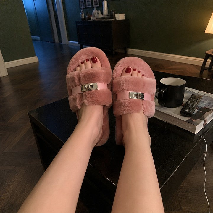 A woman with her feet up on a low table in blush pink fur slippers
