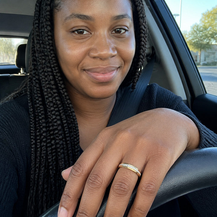 A woman in a parked car with the Gold Crystal Spinner Anxiety Ring on her hand