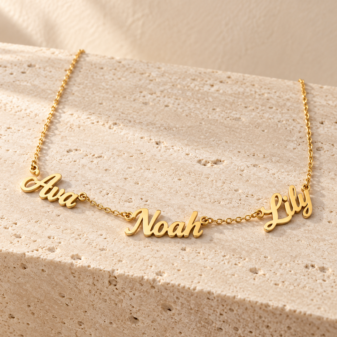 Kindred multi-name necklace in gold with three cut-out script names linked into a fine chain