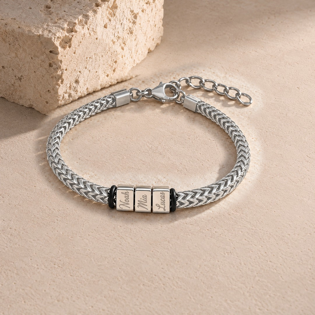 Harbor name bracelet in silver with three engraved name blocks, laid on pale stone