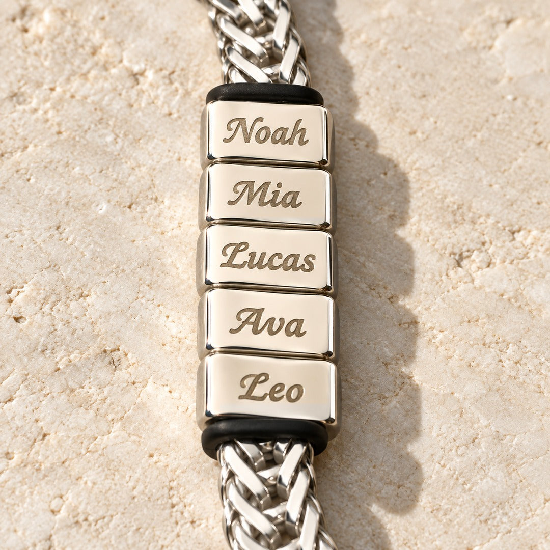 Close-up of five engraved name blocks with a stopper ring at each end, silver finish