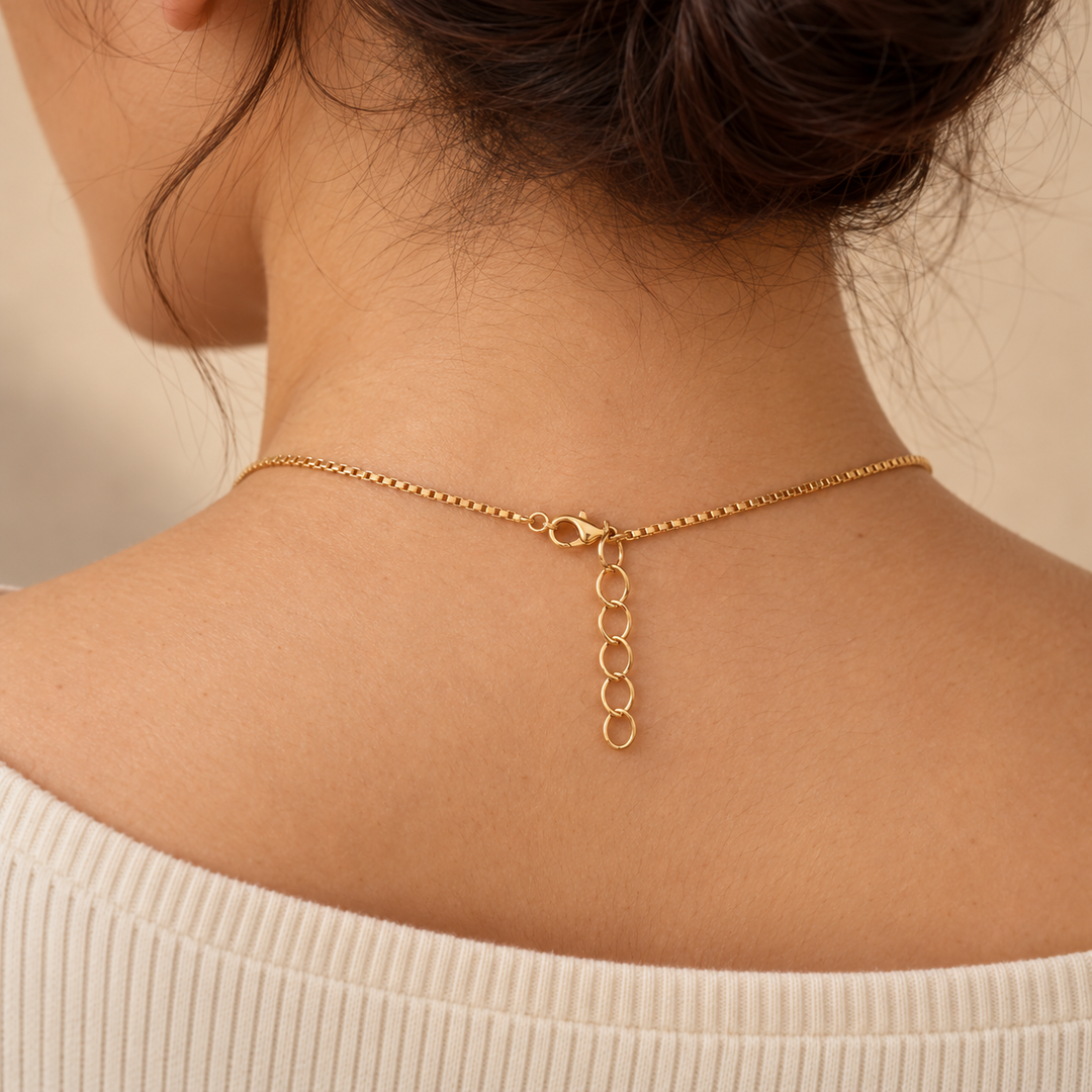 Back of the neck showing the gold-tone box chain, lobster clasp and extender links of the necklace