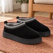 One pair of Black Alder platform slippers on a rust-coloured rug.