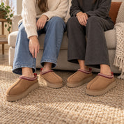 Two people seated together wearing Chestnut Alder slippers.