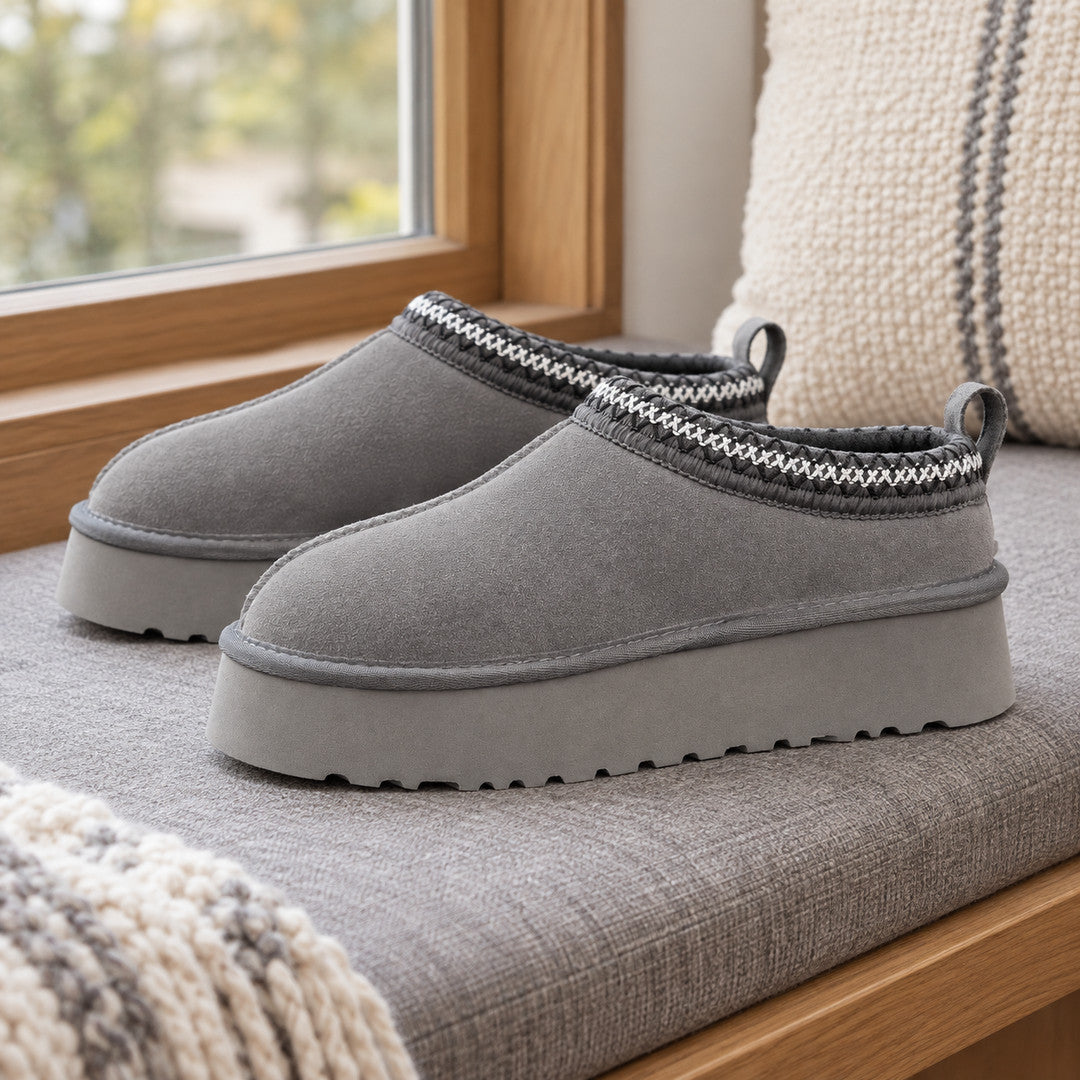 One pair of Grey Alder platform slippers on a window bench.