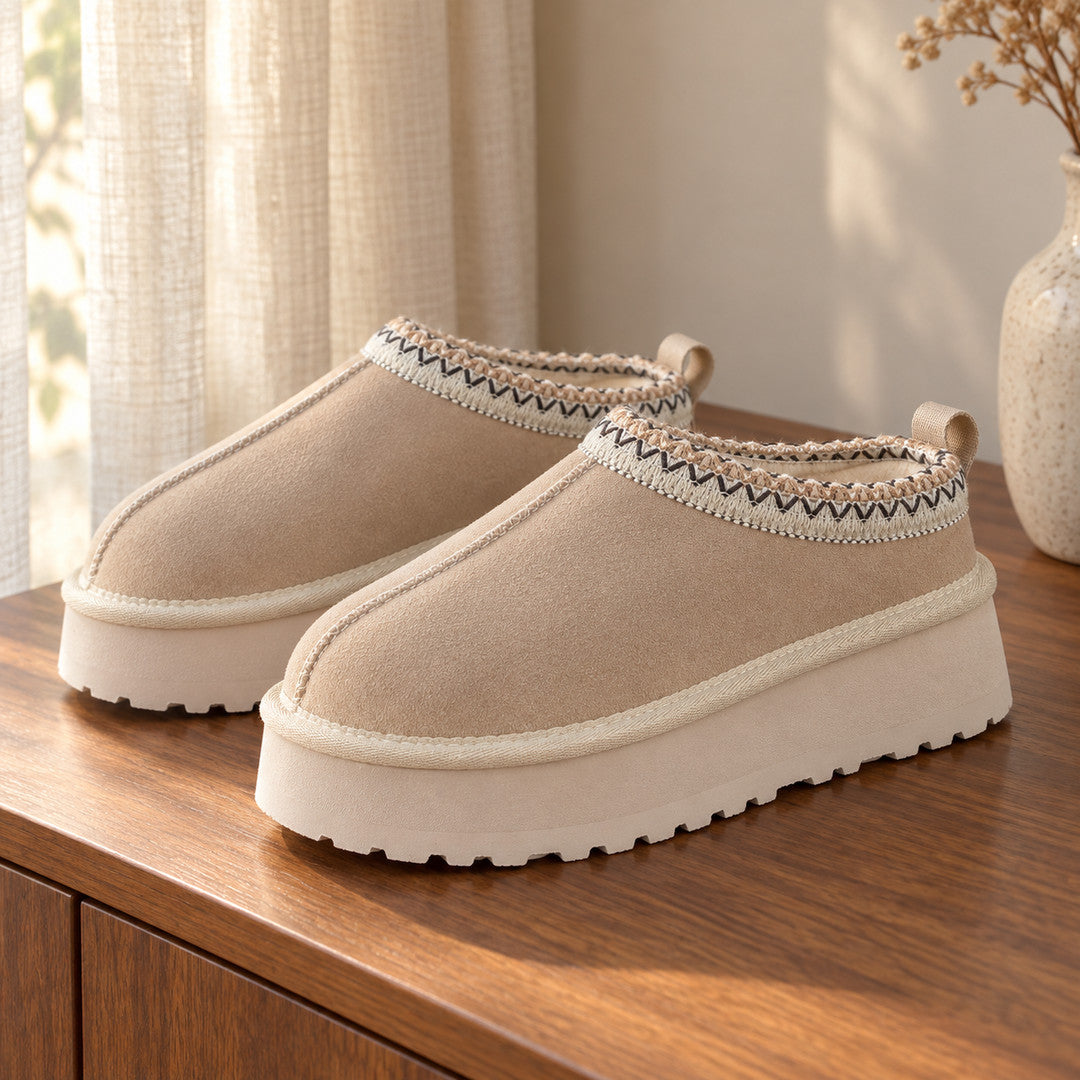 One pair of Sand Alder platform slippers on a wooden console.