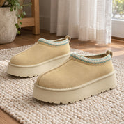Mustard Blue Stripes Alder slipper pair on a woven rug by a window.