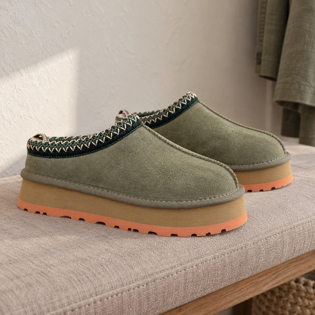 Olive Green Alder slipper pair with coral sole edges on a padded bench.