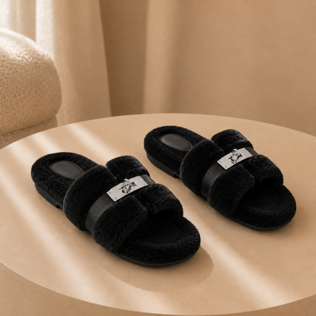 A pair of black fur slippers on a warm plaster plinth