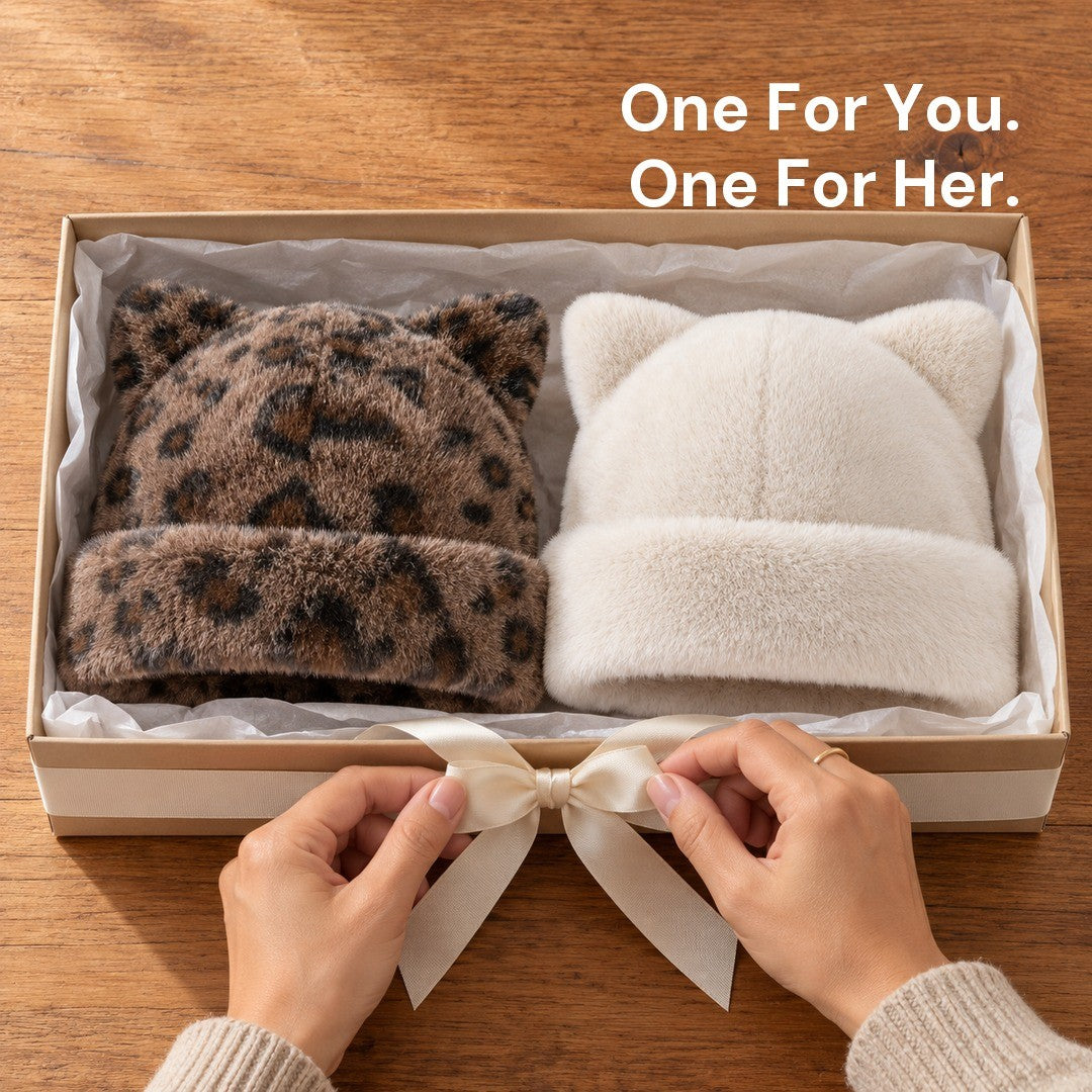 Hands tying a ribbon on a gift box holding a Leopard and a White Cleo cat ear hat.