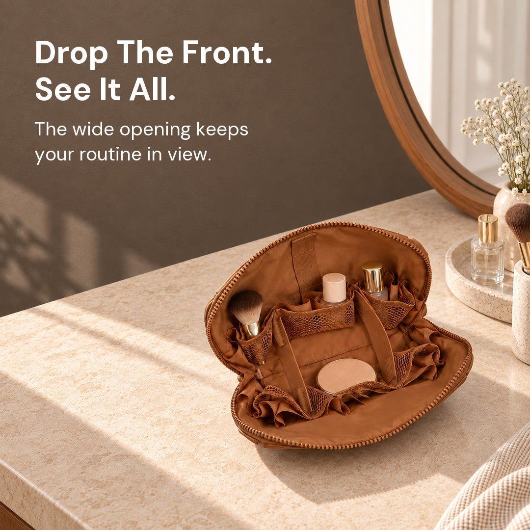 Open Brown Clara with two bottles, a compact and a brush in its flexible interior on a vanity