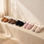Haven slippers in Chestnut, Coffee, Black, Blush Pink and Khaki, arranged as five pairs on a warm stone bench.
