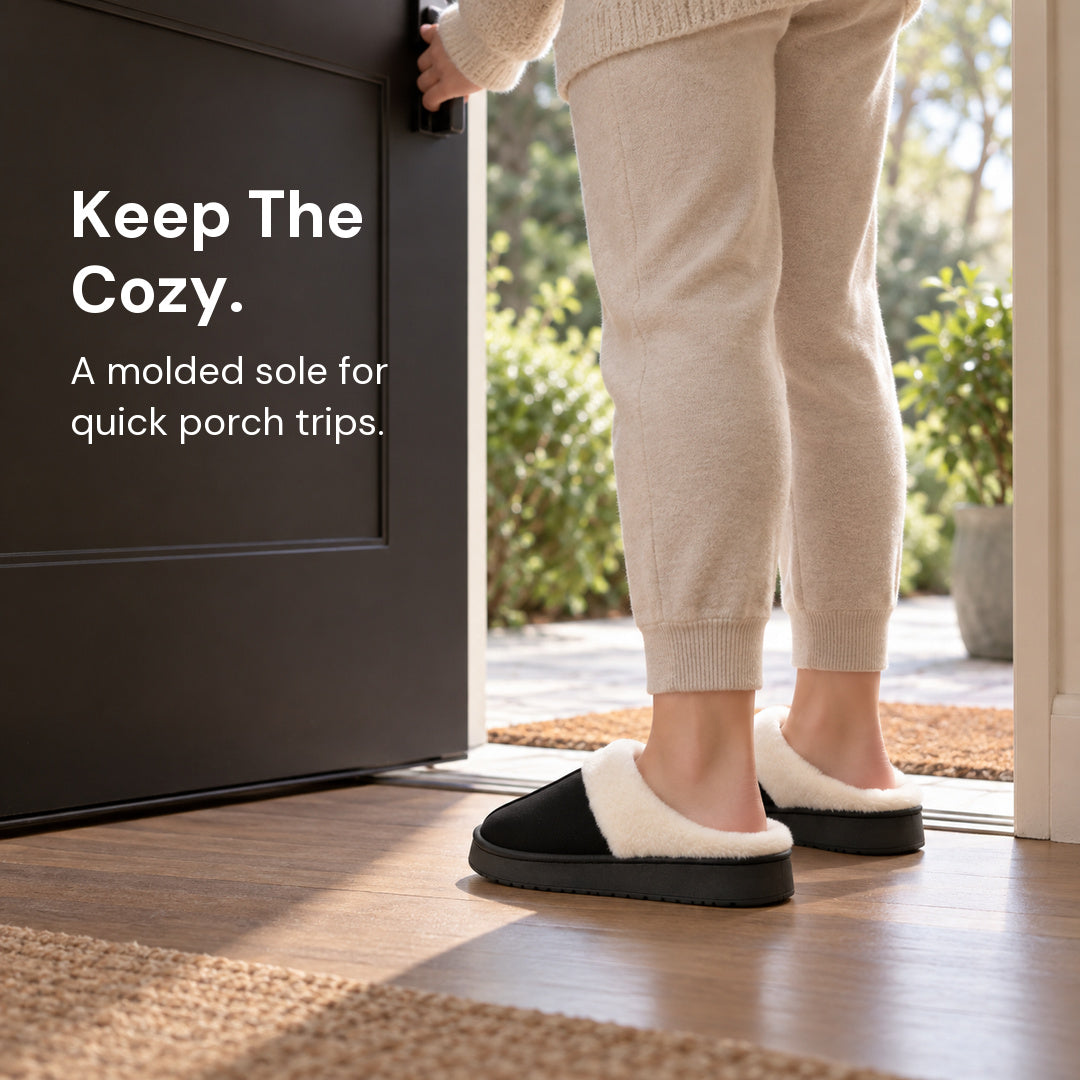 Black Haven slippers worn at a dry doorway while opening the door, viewed from behind and to the side.