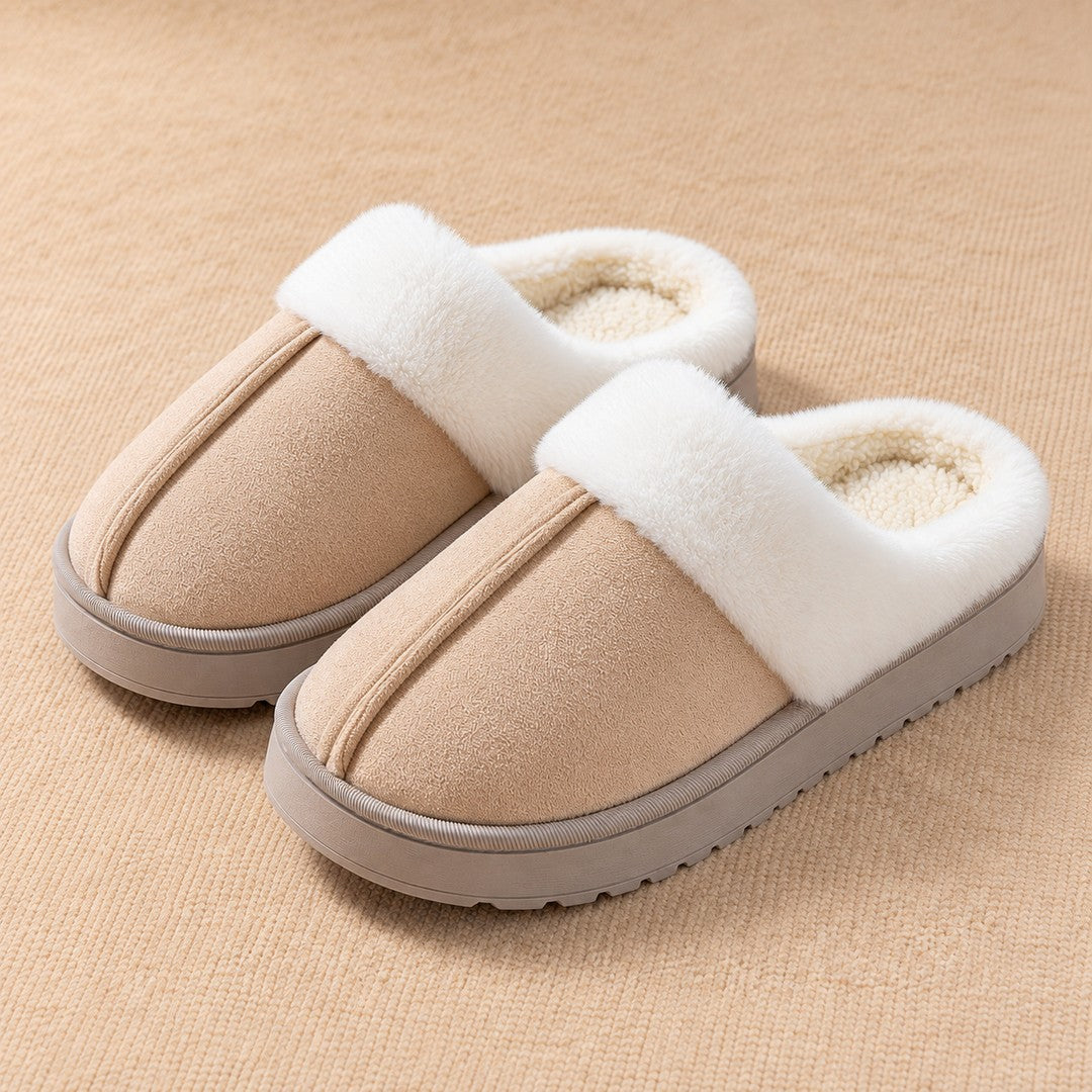 A pair of Khaki Haven slippers with white plush collars on a warm cream textile surface.