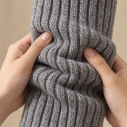 Hands scrunching an Adirena Sunday Leg Warmer in Charcoal, showing the soft rib knit close up.