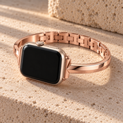 Blusharc rose gold watch band on a watch, resting on pale stone