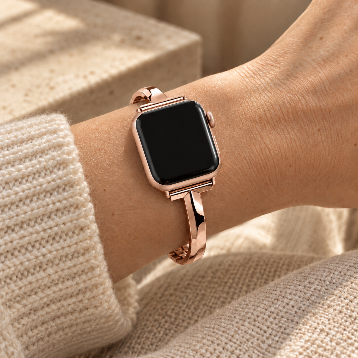 Blusharc rose gold watch band worn on a wrist beside a cream knit sleeve