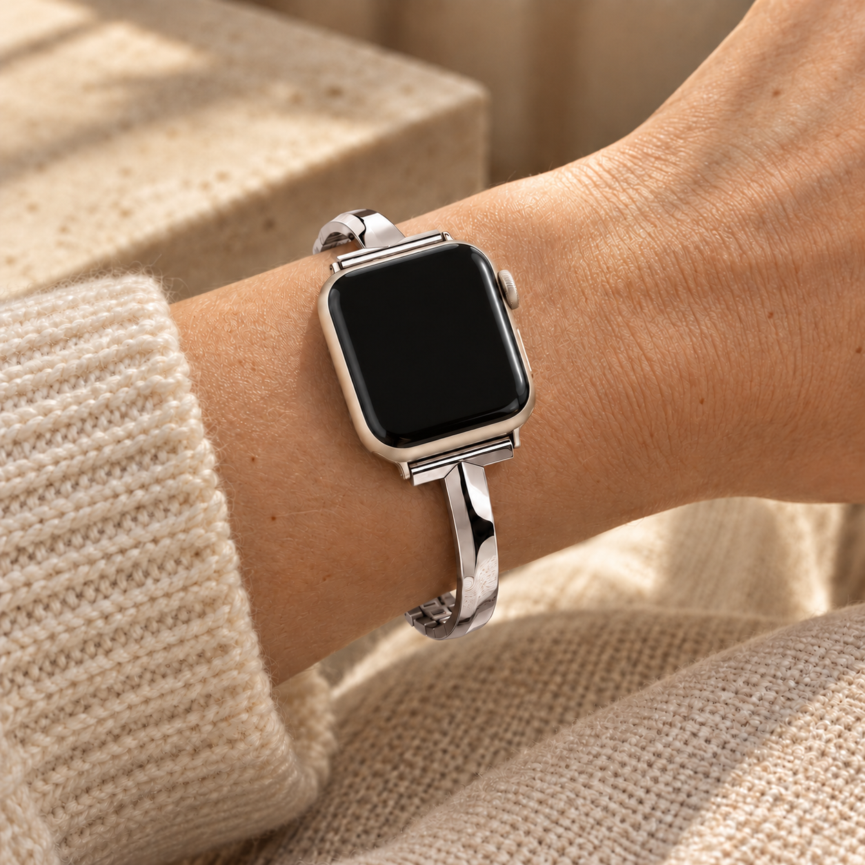 Moonrill silver watch band worn on a wrist beside a cream knit sleeve
