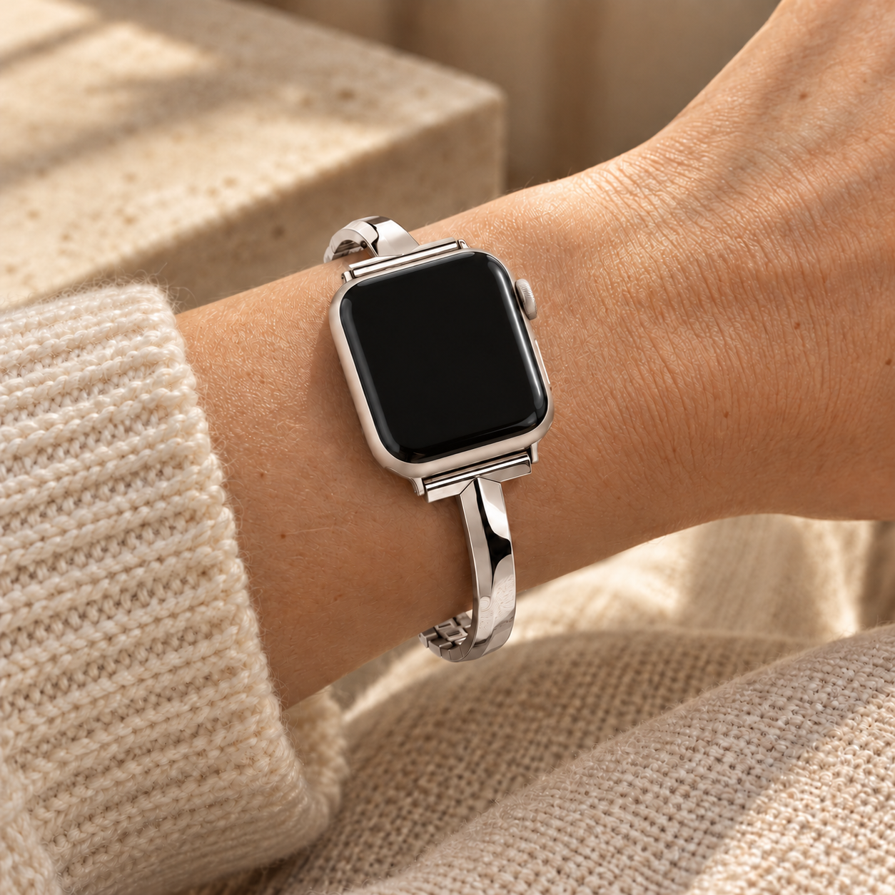 Dawngleam starlight watch band worn on a wrist beside a cream knit sleeve