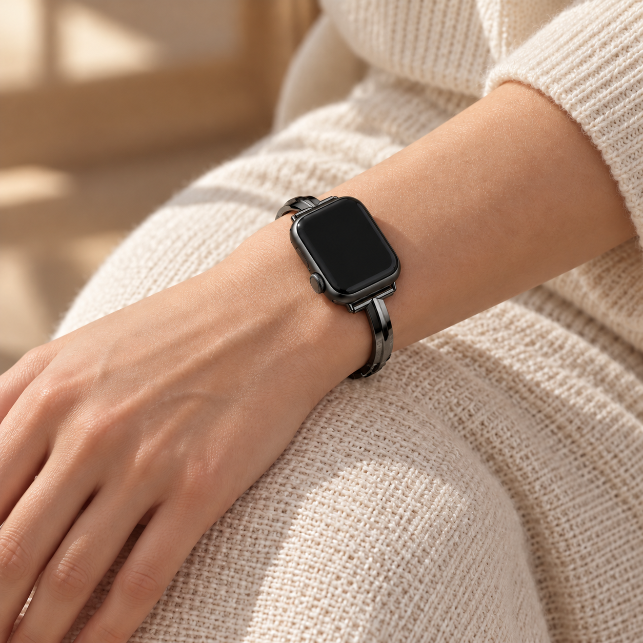 Nightglint black watch band worn on a left wrist resting on a knee