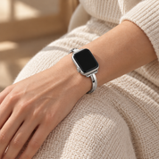 Moonrill silver watch band worn on a left wrist resting on a knee