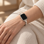 Dawngleam starlight watch band worn on a left wrist resting on a knee