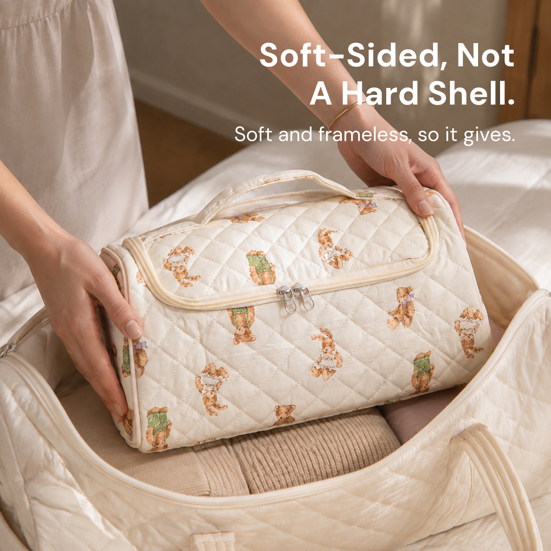 A teddy-print quilted hair-tool case being lowered flat into an open canvas weekender bag on a bed