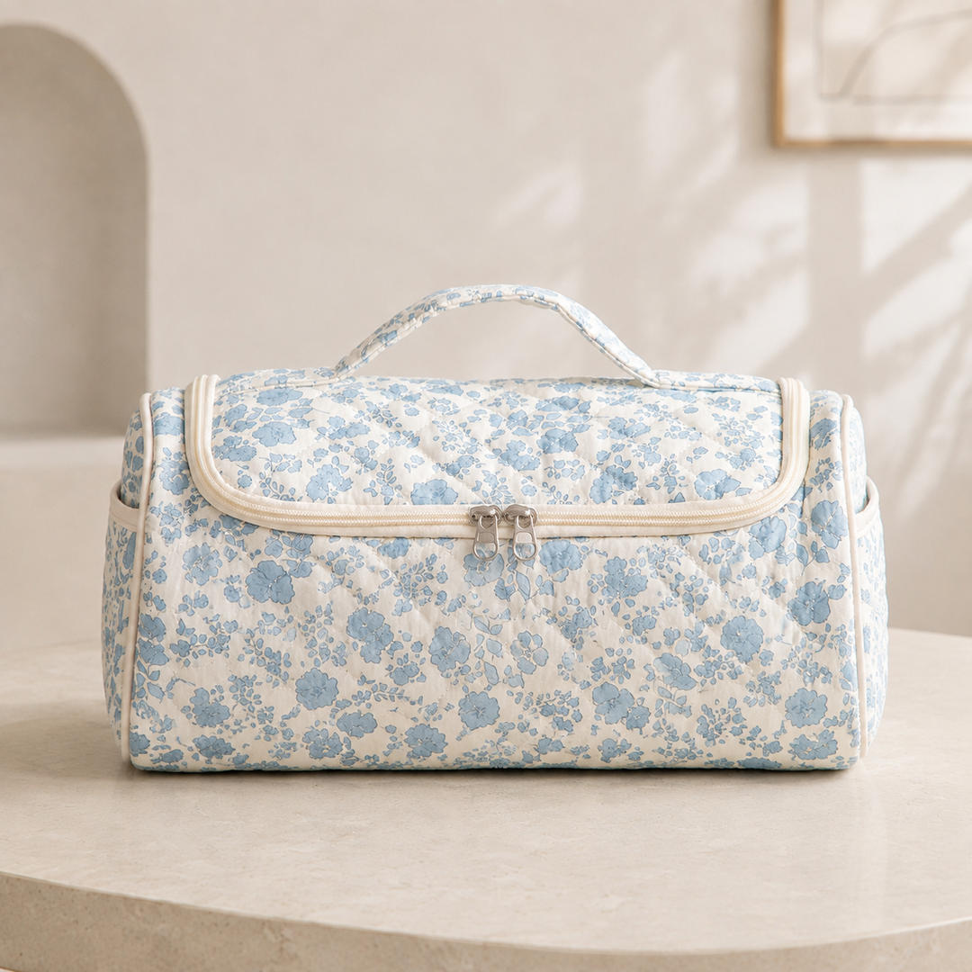 A quilted hair-tool case in the blue floral pattern, closed and seen straight on