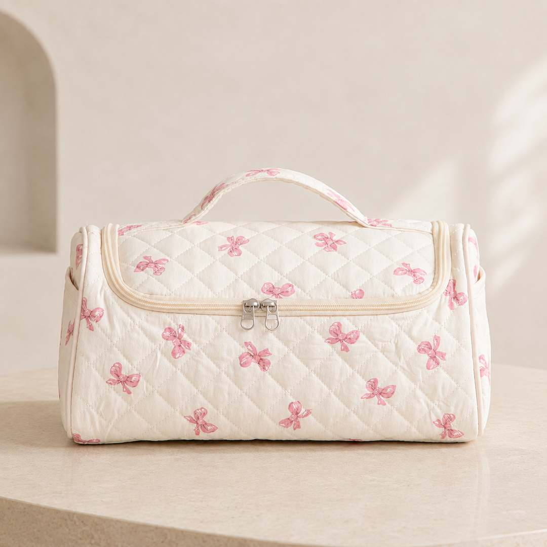 A quilted hair-tool case in the pink bow pattern, closed and seen straight on