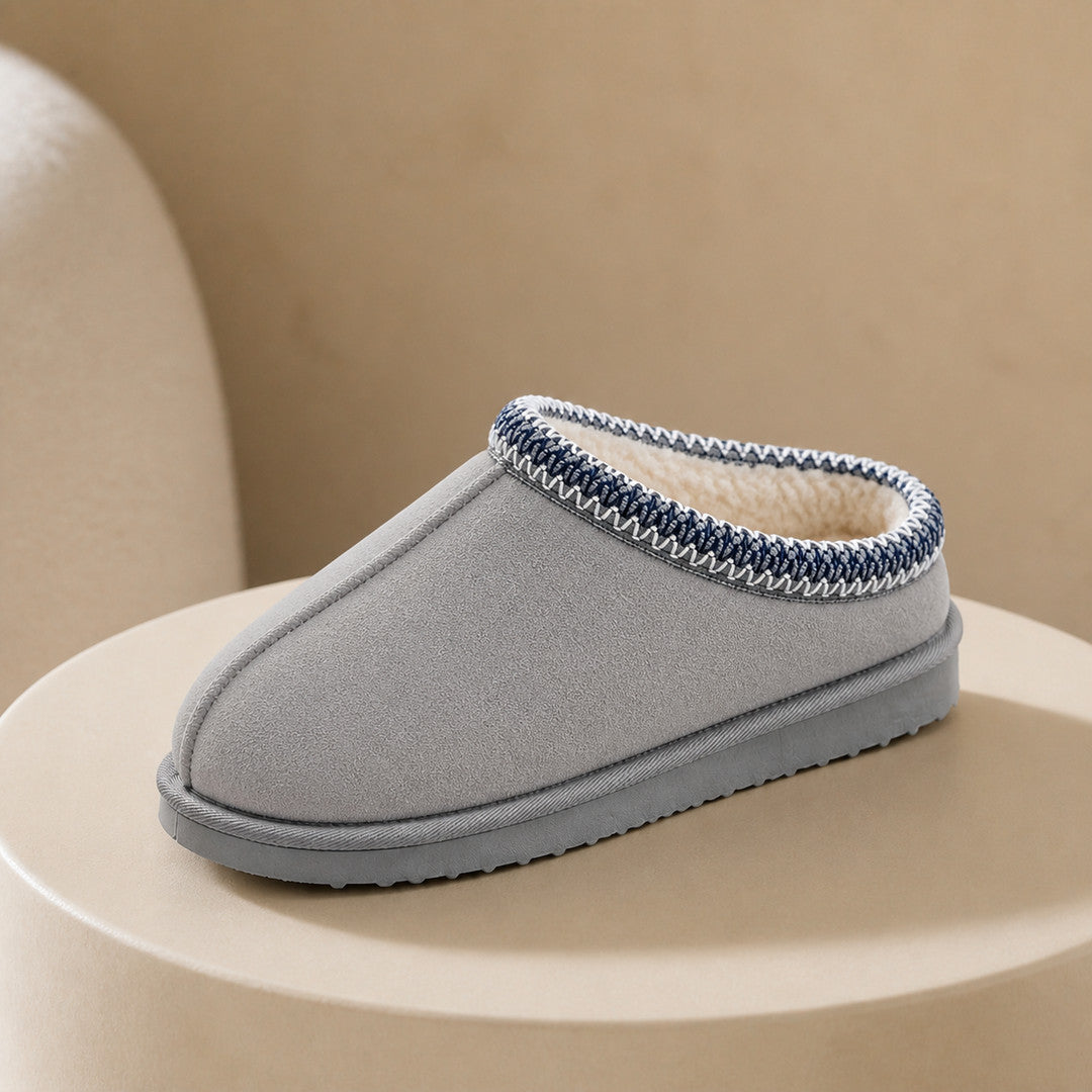 One grey slipper on a warm plaster plinth