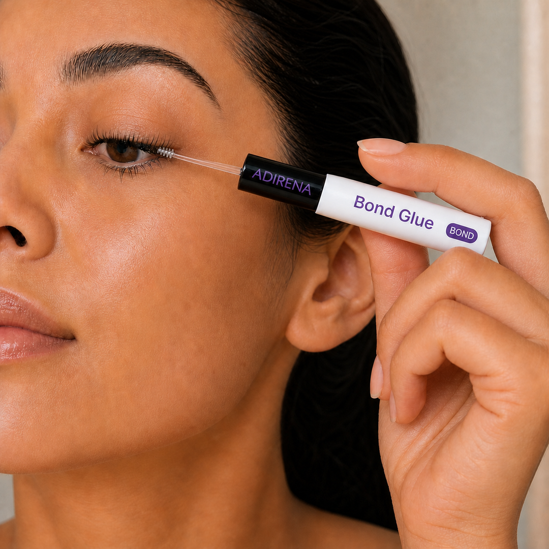 Woman applying Adirena Lash Bond & Seal at her lash line with the clear spoolie