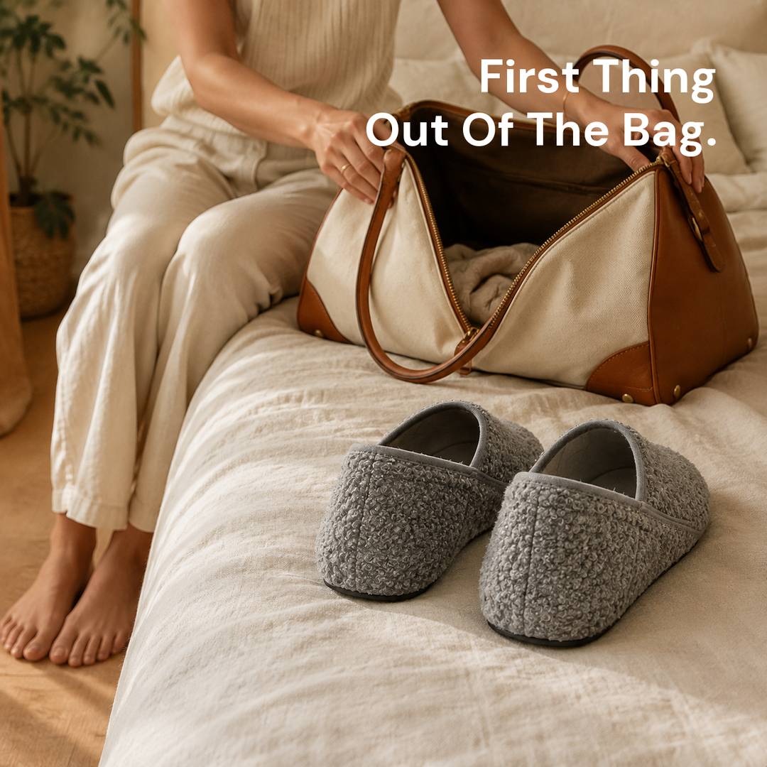 A hand lifting a pair of slipper socks out of an open suitcase