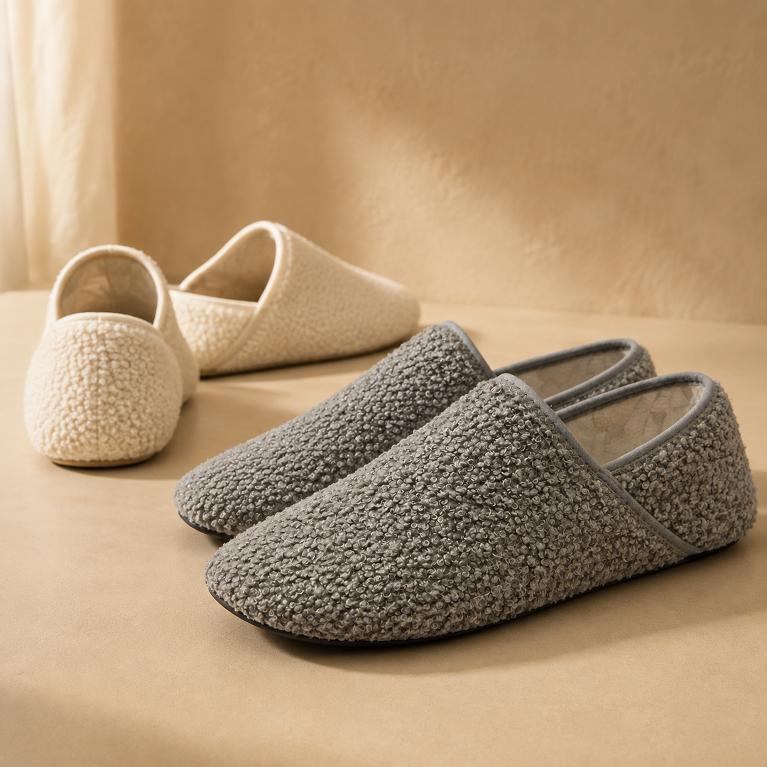 Two pairs of Adirena barefoot travel slipper socks side by side on a pale plaster surface
