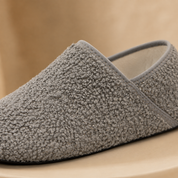 The throat and side seam of a grey slipper sock seen close up
