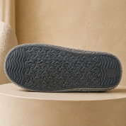 The rubber sole of a slipper sock, rippled at the toe and heel