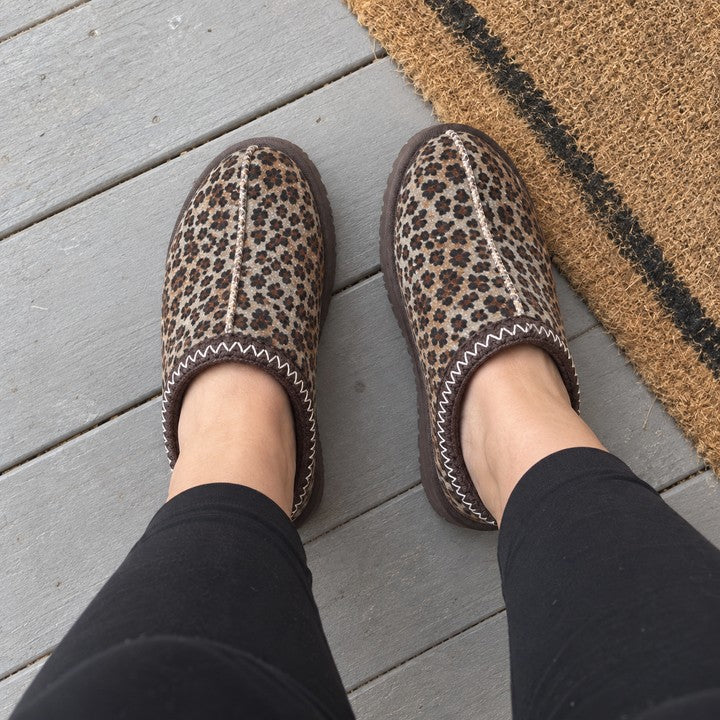 Illustrative wearer POV of Thin Leopard Aspen slippers on a porch.