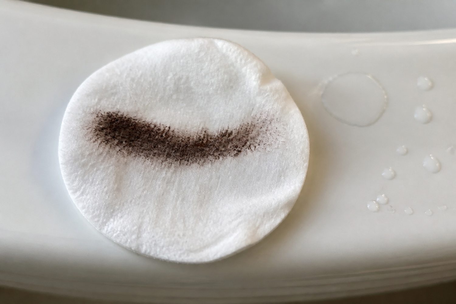 Used cotton pad with a brown streak