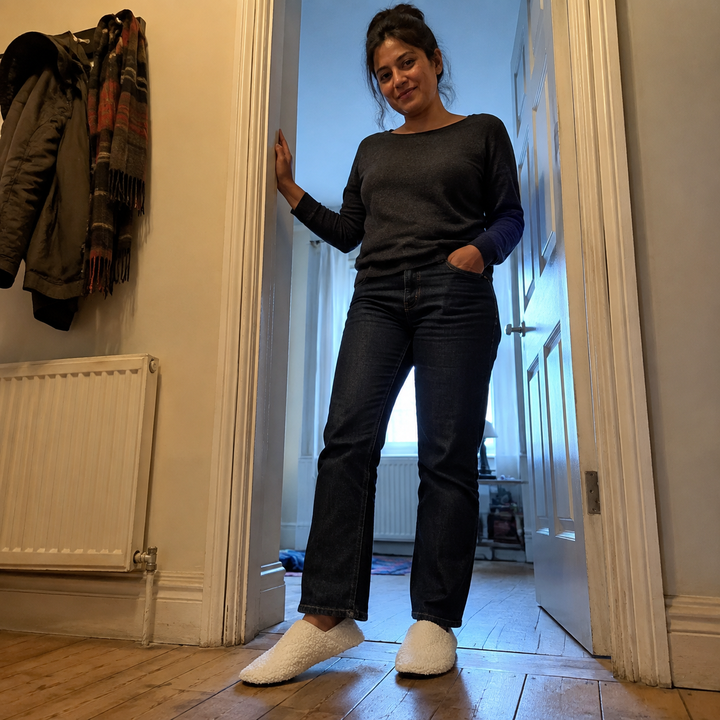 A woman standing in a doorway wearing barefoot travel slipper socks