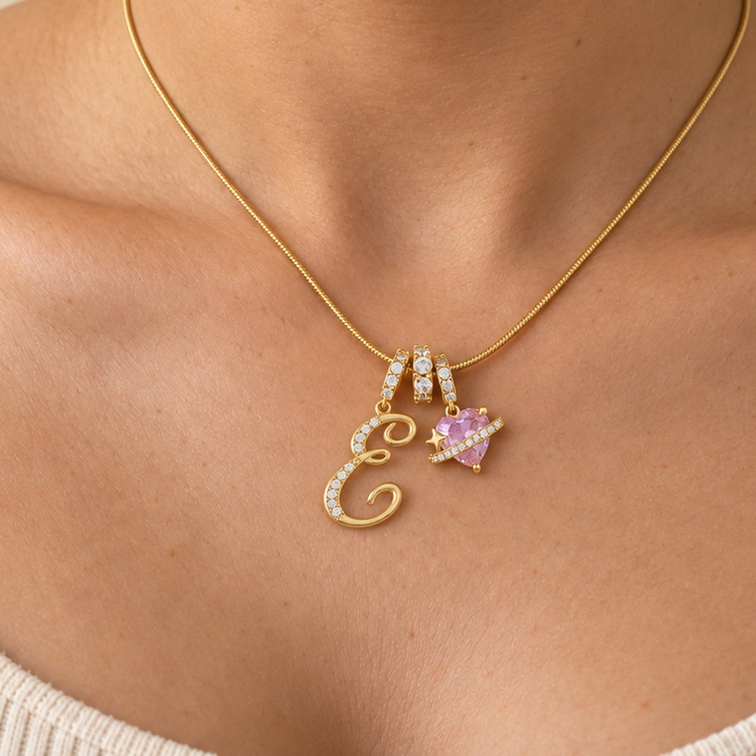 Cherie in gold, worn, the letter and pink heart resting at the neckline