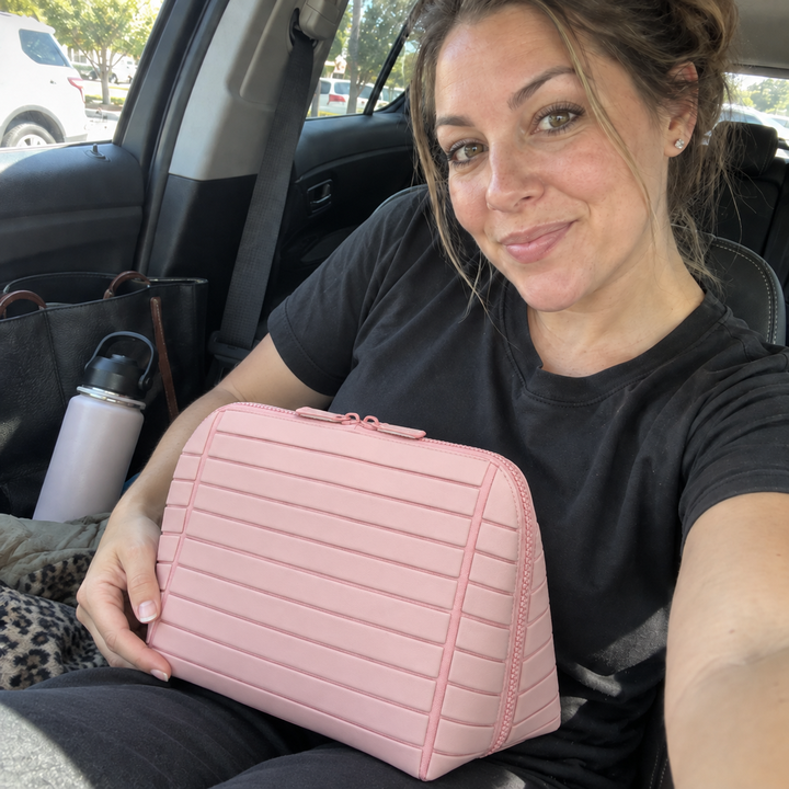 Woman steadying closed Pink Clara on her lap in a parked car