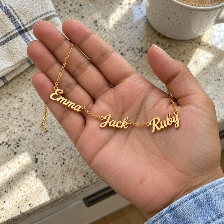 The gold name necklace held in an open palm, everyday phone photo