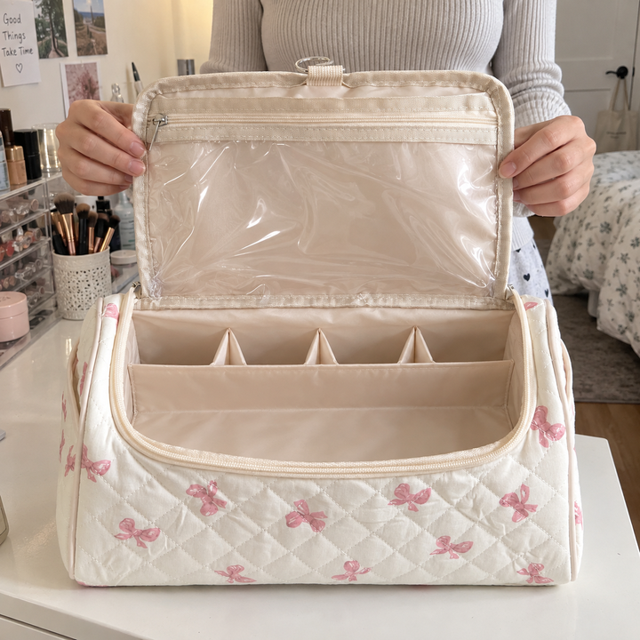 A woman lifting open the lid of a pink-bow quilted hair-tool case on a bedroom vanity