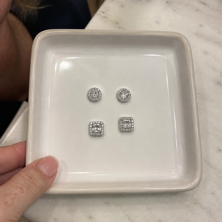 Woman styling a two-pair halo stud set
